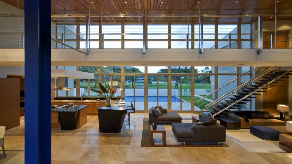 A spacious living room with a staircase and a large window, creating a bright and airy atmosphere.